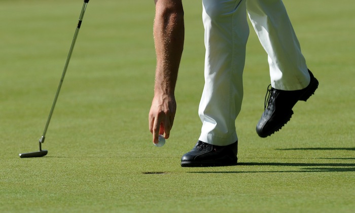 Golfer retrieving ball